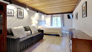 A bedroom with a bed, a sofa, and a TV. - Slopeside Condo with Fireplace (Mammoth Lakes)
