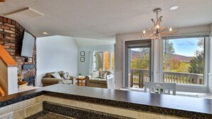 Eine Küche mit Granit-Arbeitsplatten, einer Wand mit Backsteinoptik und Blick auf einen Balkon mit weißer Reling.