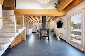 Ein modernes Interieur mit Treppe, Kamin und großem Fenster mit Blick.