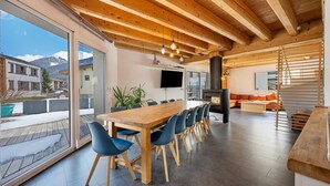 Een moderne keuken met een houten tafel en stoelen, een televisie en een open haard.