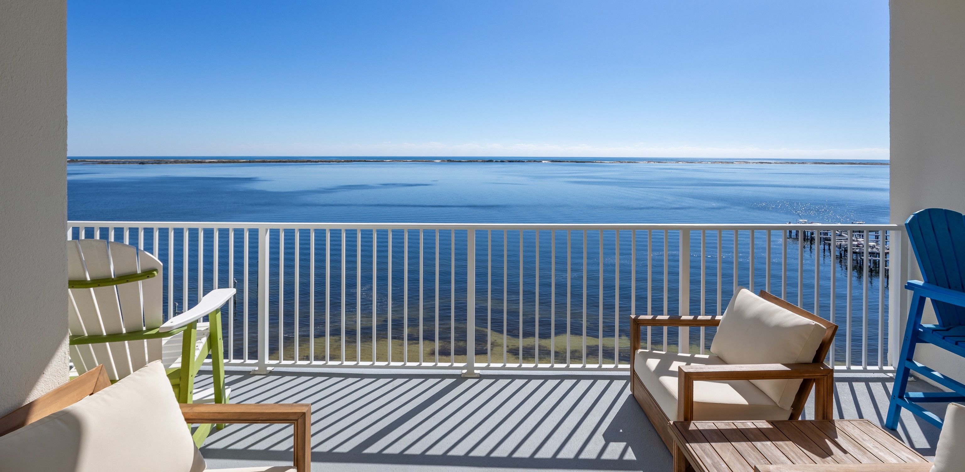 Un balcon avec vue sur la mer, comprenant deux chaises et une table.