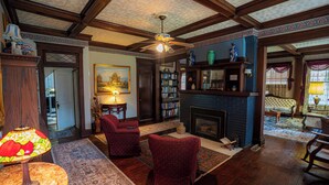 A traditional living room with a fireplace, bookshelves, and comfortable seating. - Warm, Cozy and Historic (Poplar Bluff)