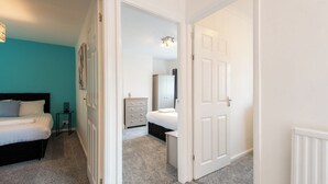 A bedroom with a bed, bedside table, and a dresser. - Red Courts (Brandon)