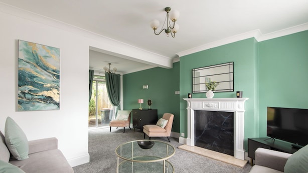 A living room with a fireplace, a television, and a sofa. - Red Courts (Brandon)