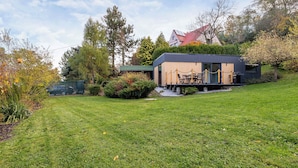 A modern house with a deck, surrounded by a well-maintained lawn and trees. - Modern House | Garden | Air Conditioning | Close to the Forest (Bielsko-Biała)