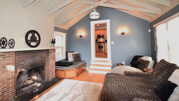 A cozy living room with a fireplace, a comfortable sofa, and a staircase leading to an upper level.