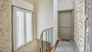 A staircase with stone walls, a door, and a window.