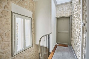 A staircase with stone walls, a door, and a window.