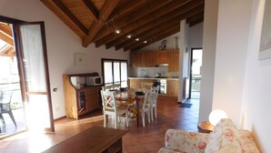 A spacious living area with a wooden bench, a floral sofa, and a dining table set for four. - Rosemary 2 apartment in Agra with pool (Agra)