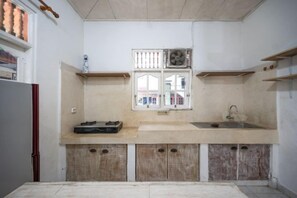 Una cocina funcional con ventana, un lavamanos y armarios.