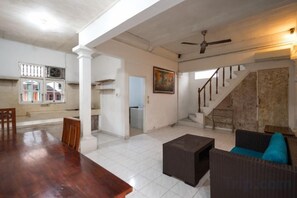 Amplia sala de estar con mesa de comedor, sofá y escalera.