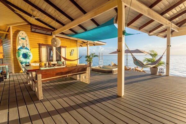 A wooden deck with a bar area, a hammock, and a view of the sea. - Feel right at home in paradise in the eco friendly, off-grid home on Isla Colon. (Isla Colon)