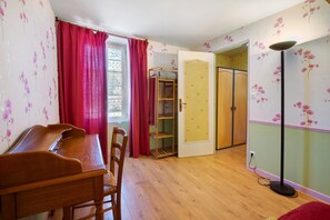A room with a wooden desk, chairs, a wardrobe, and a floor lamp. - Gîte “Chez Manon” with Private Garden (Massangis)