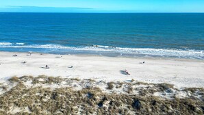 A beach with people and dogs, clear skies, and calm sea. - Sunset Rentals | Island Club 2403 (Hilton Head Island)