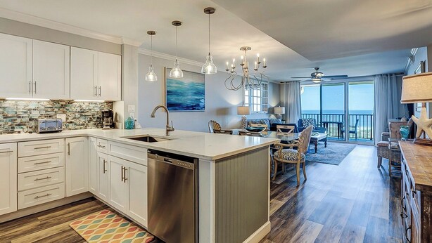 A modern kitchen with a dishwasher, a dining area with a view, and a living room with a ceiling fan. - Sunset Rentals | Island Club 2403 (Hilton Head Island)