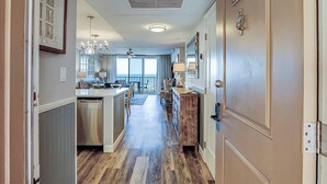 A hallway with a kitchen, dining area, and a door labeled '2403'. - Sunset Rentals | Island Club 2403 (Hilton Head Island)