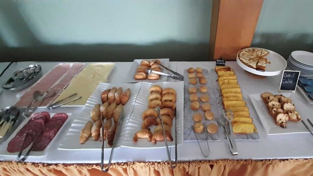 A buffet table with various food items and utensils. - HOTEL CENTENARIO (Atlántida)