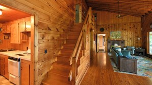 Ein Holzblockhaus mit Küche, Essbereich und Wohnzimmer.