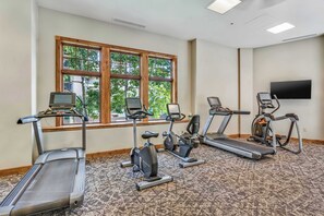 Ein Fitnessraum mit Laufbändern, Ergometer und einem Fernseher.