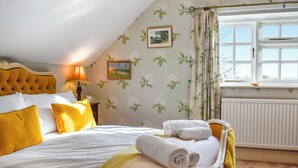 A bedroom with a bed, pillows, a lamp, a window, and a radiator. - 1 bedroom accommodation in Flore (Flore)