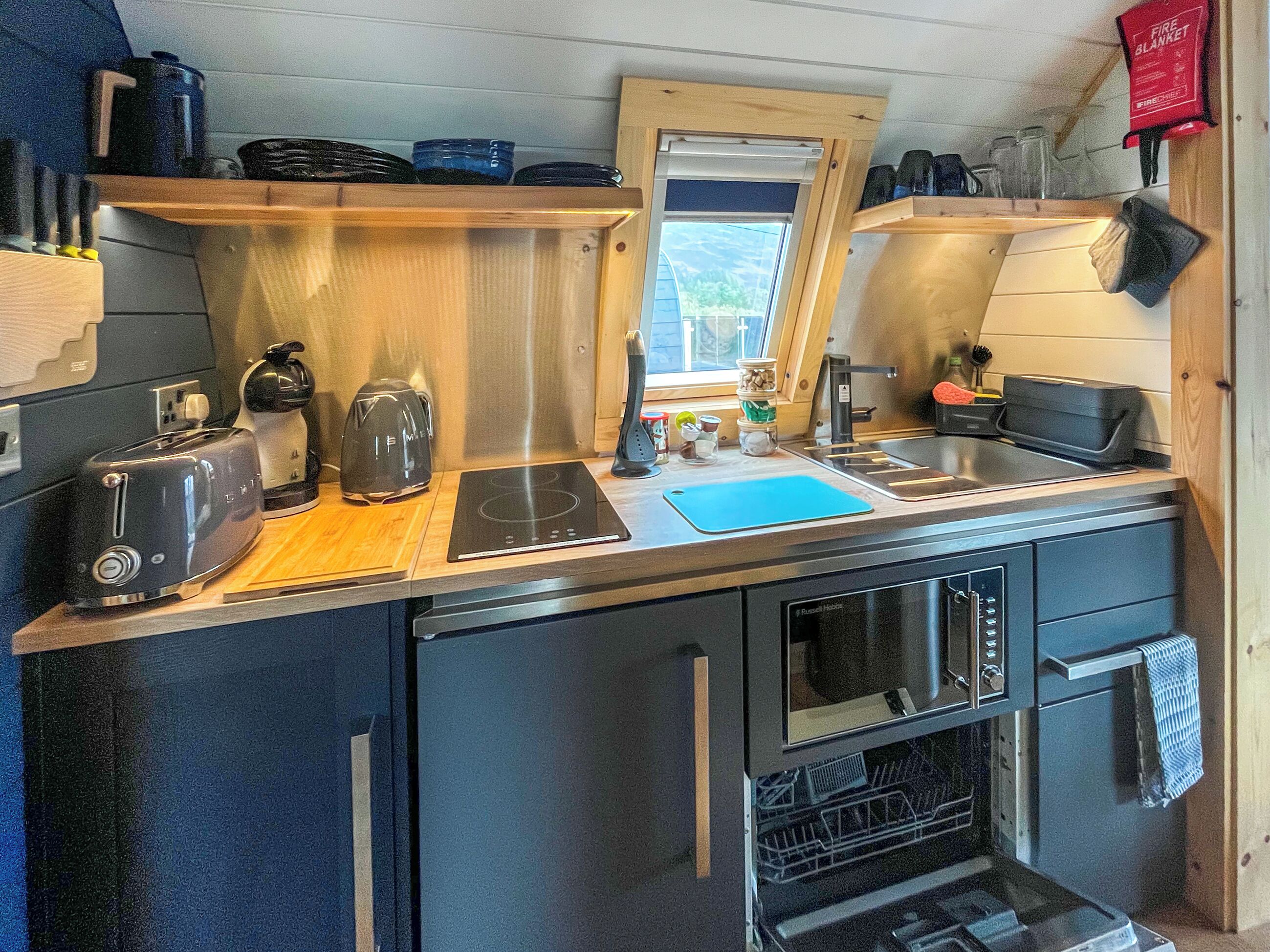 Una cocina compacta con tostadora, hervidor, pileta y horno.