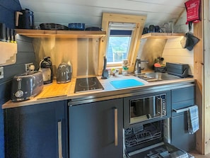 A compact kitchen with a toaster, kettle, sink, and oven. - 1 bedroom accommodation in Avernish, near Kyle (Avernish, near Kyle)