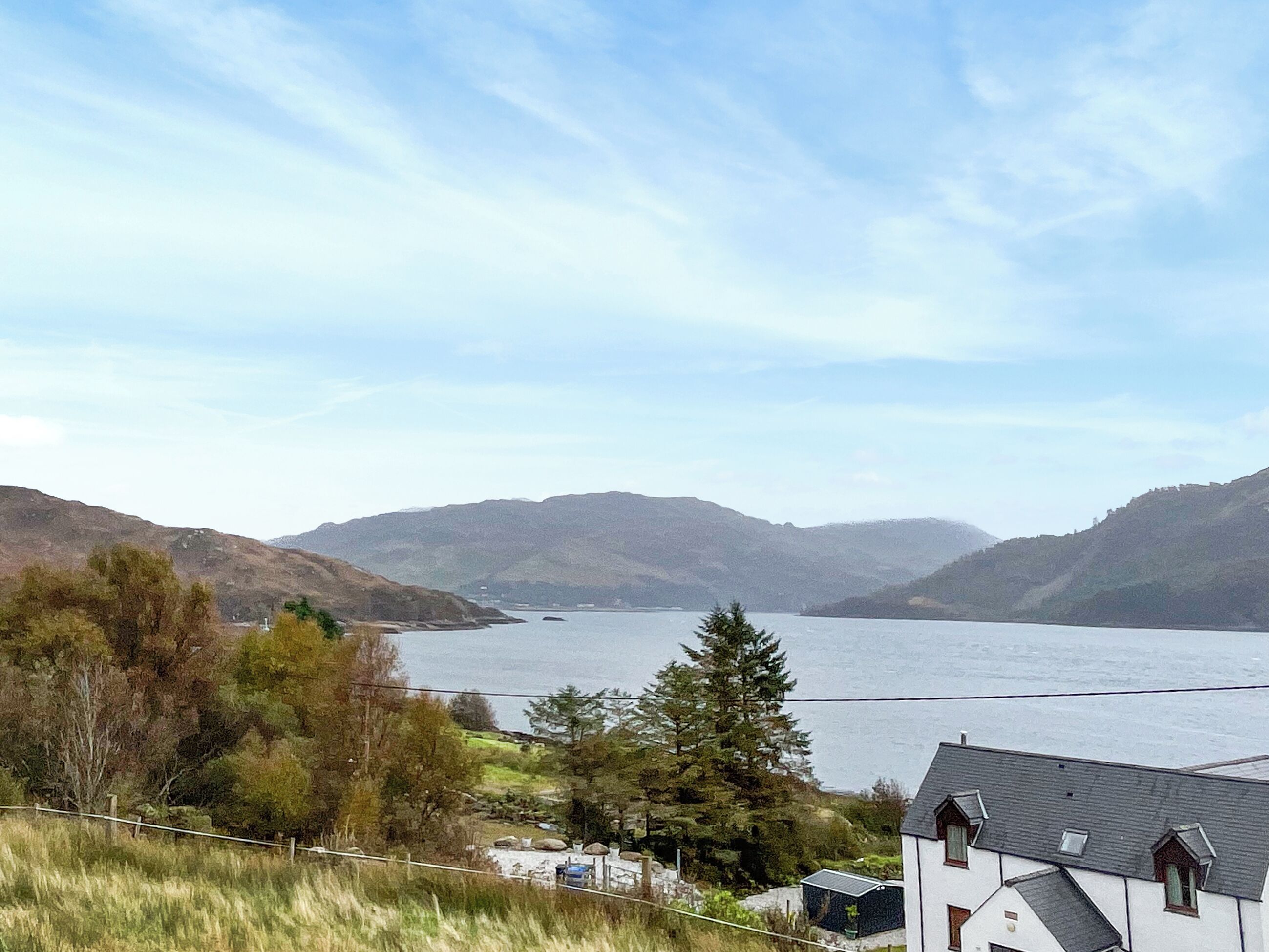 A house with a view of a lake and mountains.
