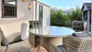 A covered patio with wicker furniture and a glass table. - Beautiful home in Voorthuizen (Voorthuizen)