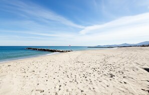 A wide sandy beach with footprints, a rocky breakwater, and a clear blue sky. - 2 bedroom nice apartment in Saint-Cyprien Plage (Saint-Cyprien Plage)