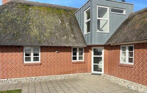 A house with a thatched roof and a modern extension with large windows. - Nice home in Blåvand with sauna (Blåvand)