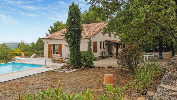 Una casa con piscina, area salotto esterna e giardino.