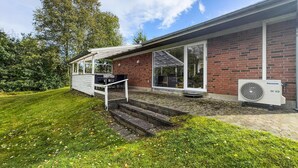 A house with a patio, a brick exterior, and a large window. - 3 bedroom stunning home in Tarm (Tarm)