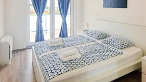 A hotel room with a bed, a nightstand, a lamp, and a window with curtains. - Amazing home in Privlaka with sauna (Privlaka)