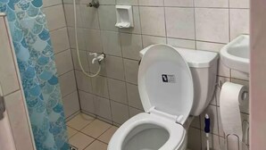 Une salle de bain équipée de toilettes, d’un bidet et d’une douche.