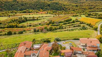 Ein Wohngebiet mit Reihenhäusern, einer kurvenreichen Straße und einer hügeligen Landschaft mit Feldern.