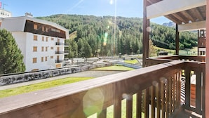 A hotel with a balcony overlooking a forested area and a mountain in the background. - Studio Valleverde 11D Ski In Ski Out (Sestriere)