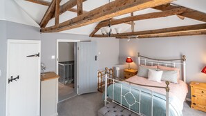 Une chambre à coucher avec un lit, une table de chevet, une commode et un plafond en bois.