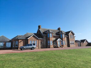 A large brick house with multiple windows and a driveway.