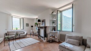 Uma sala de estar ampla com lareira, janelas grandes e vista para as montanhas.