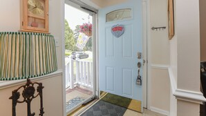 A door with a heart-shaped sign, a wooden clock, and a striped curtain. - Adorable pet-friendly fenced home in Hampton! Welcome to Redheart Cottage <3 (Hampton)