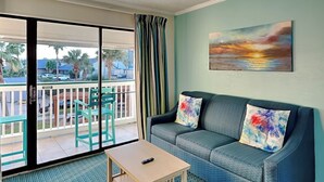 A living room with a sofa, two chairs, a coffee table, and a painting on the wall. - Casa Del Mar 184 | Private Balcony, Partial Beach Views (Galveston)
