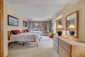 A bedroom with two beds, a dresser, a mirror, and a window with curtains. - Spacious 4-Bedroom in Keystone-Walk to lifts! (Keystone)
