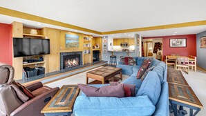 A modern living room with a fireplace, a large sofa, a coffee table, and a television. - Spacious 4-Bedroom in Keystone-Walk to lifts! (Keystone)