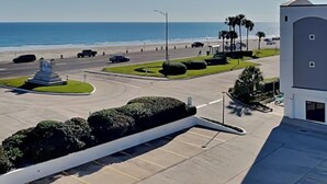 Un estacionamiento con vista a la playa y al océano, un monumento y un edificio con cúpula.