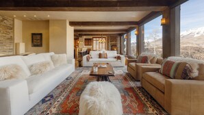 A spacious living room with a large window, a fireplace, and a cozy seating area. - See Forever Condo by InvitedHome | Ski Valet, Walk to Ski, Hot Tub, Balcony (Mountain Village)