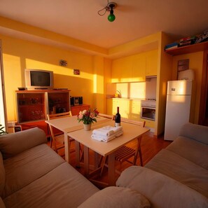 Apartamento família, vista para a montanha | Área de estar | TV de tela plana 42 polegadas com canais a cabo