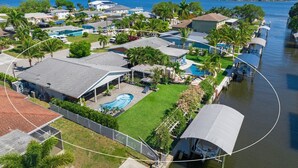 A residential area with houses, a swimming pool, and a canal. - The Waterfront Family Oasis- Pool, Dock & Relaxing Backyard (Ellenton)