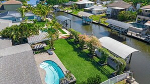A residential area with a swimming pool, boats, and a marina. - The Waterfront Family Oasis- Pool, Dock & Relaxing Backyard (Ellenton)