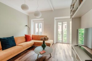 A modern living room with a sofa, a coffee table, and a TV. - Midnight Borgo - MyHomeinComo (Como)
