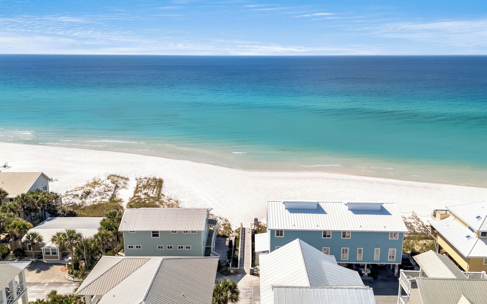 Un quartier résidentiel situé sur la côte, avec des maisons donnant sur une plage.